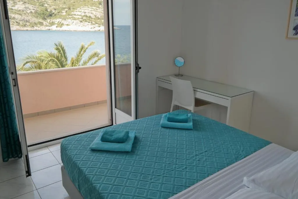 Spavaća soba apartmana s dvije spavaće sobe i dva bračna kreveta s izlazom na balkon